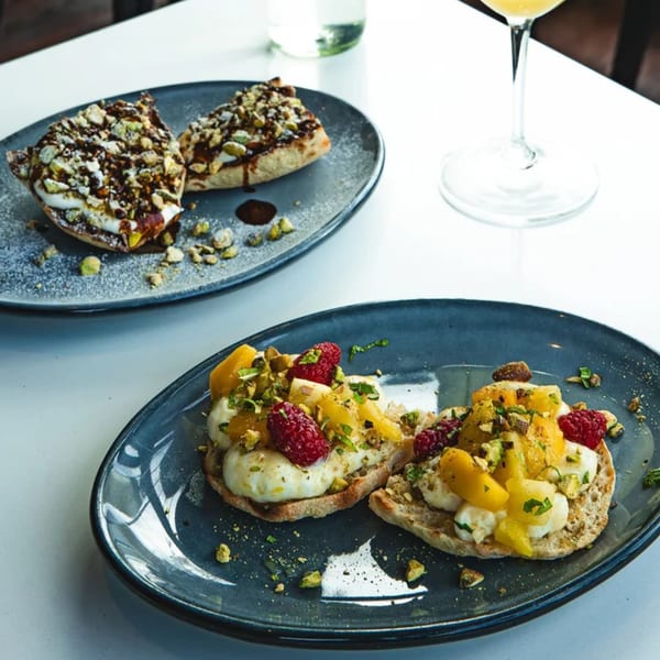 Two plates of Boa's CVC cafe food, one with fruit and cream, the other with chocolate and nuts.